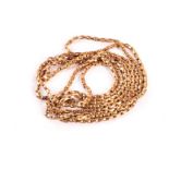 An Edwardian period 9ct gold muff chain, the long chain of oval links having watch clasp to