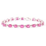 A modern silver and ruby line bracelet, each of the oval synthetic pink stones in four claw link,