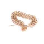 A 9ct gold bracelet, having three oval link chains united by a heart shaped clasp, approx 25g