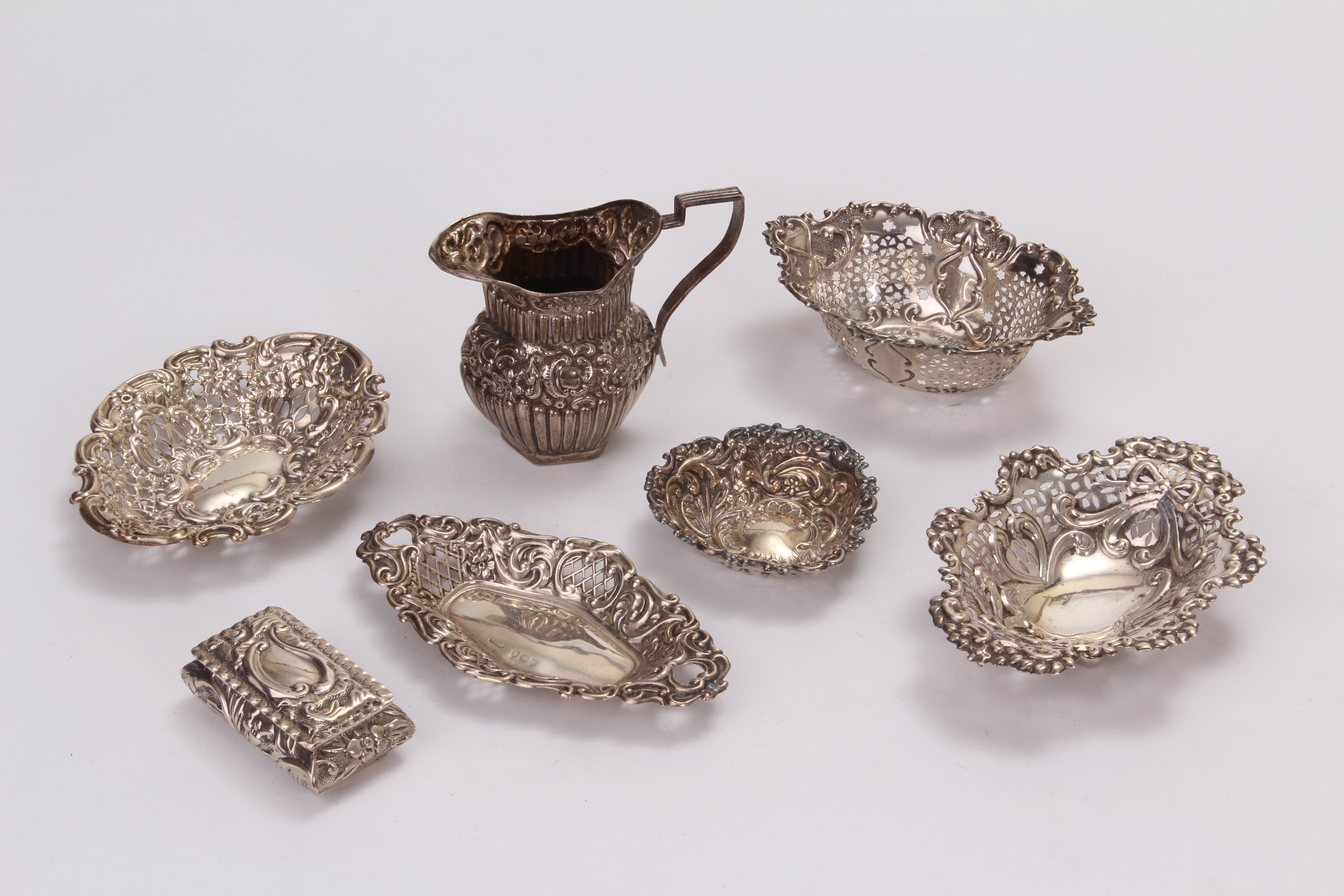 A group of seven Victorian and later silver items, including five embossed dishes, a small box and a