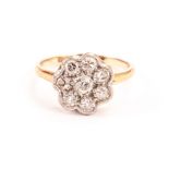 A pretty Art Deco diamond ring, the flower head platinum tablet set with old cuts on a gold band