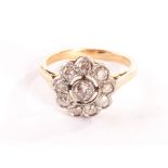 An Edwardian diamond daisy cluster, with rub over platinum mounts on a gold shank 3.8g