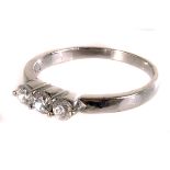 A three stone ring, the brilliant cuts in white metal mounts and band, marked 18k, one stone with