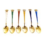 A set of six continental silver gilt and enamel spoons, having crown design to terminal, in
