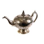 An Elkington silver plated teapot, having seated figure to lid, with engraved floral decoration to