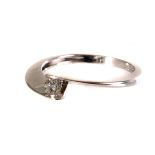 A 9ct white gold diamond crossover ring, the central round cut diamond set to either side, size M1/