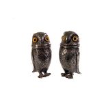 A pair of white metal owl salt and peppers, having engraved design and applied eyes