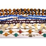 A group of hardstone bead necklaces, including a lapis lazuli example, a tiger's eye necklace, a