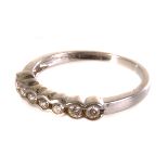 A seven stone half hoop eternity ring, the row of brilliant cuts in white metal mount marked 18k