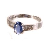 A pretty gem set dress ring, having a central oval blue stone, possibly a tanzanite, set with