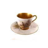 A Royal Worcester cabinnet cup and saucer, having hand painted pheasant design, heightened with