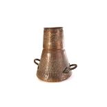 A large Eastern copper vessel, with embossed and engraved symbolic decoration, with twin handle