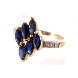 A modern gem set dress ring, having six navette shaped blue stones to tablet with three channel