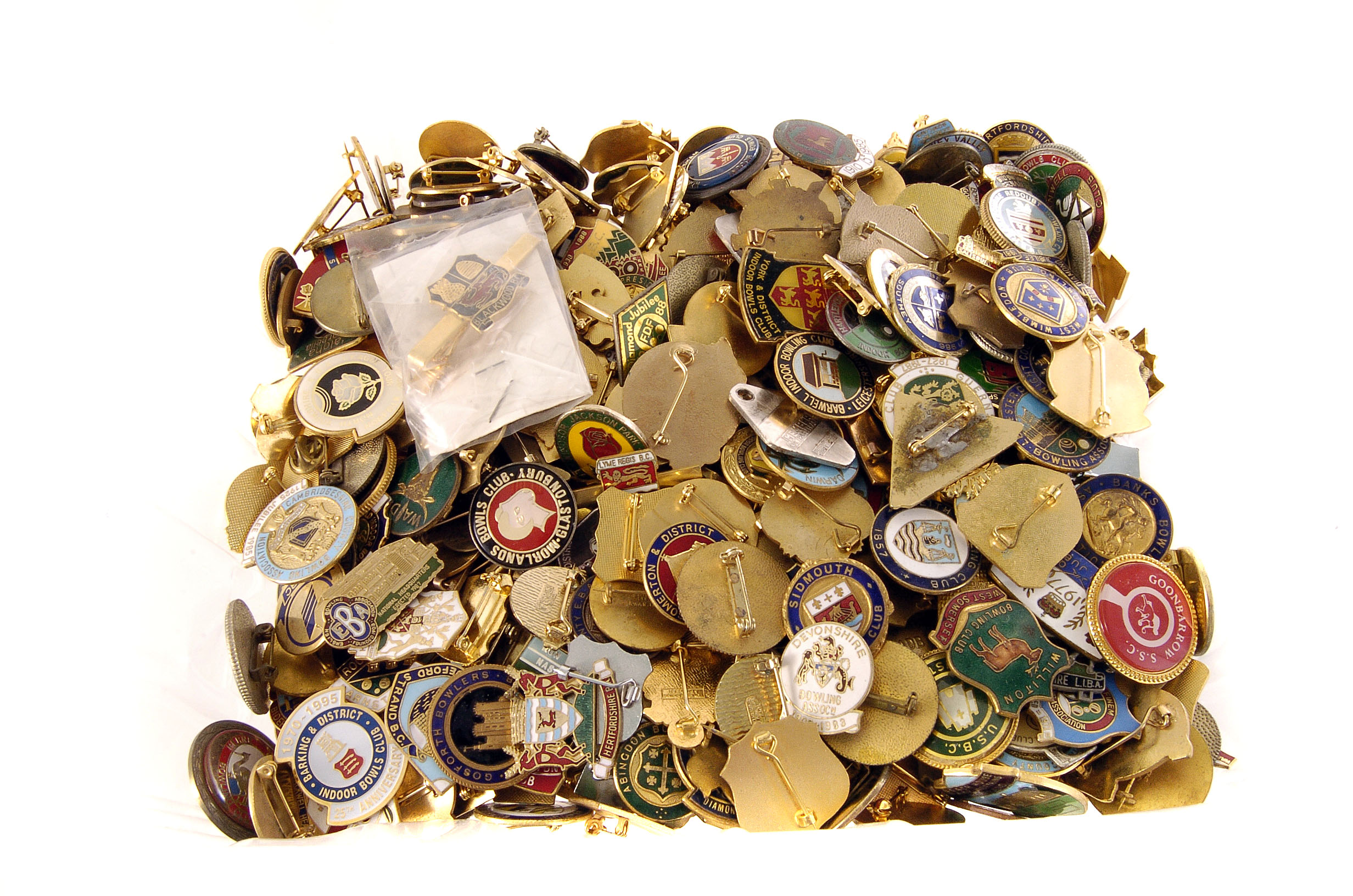 A large collection of bowling badges, including Wimbledon, Morlands, Torbay County, Cambridgeshire