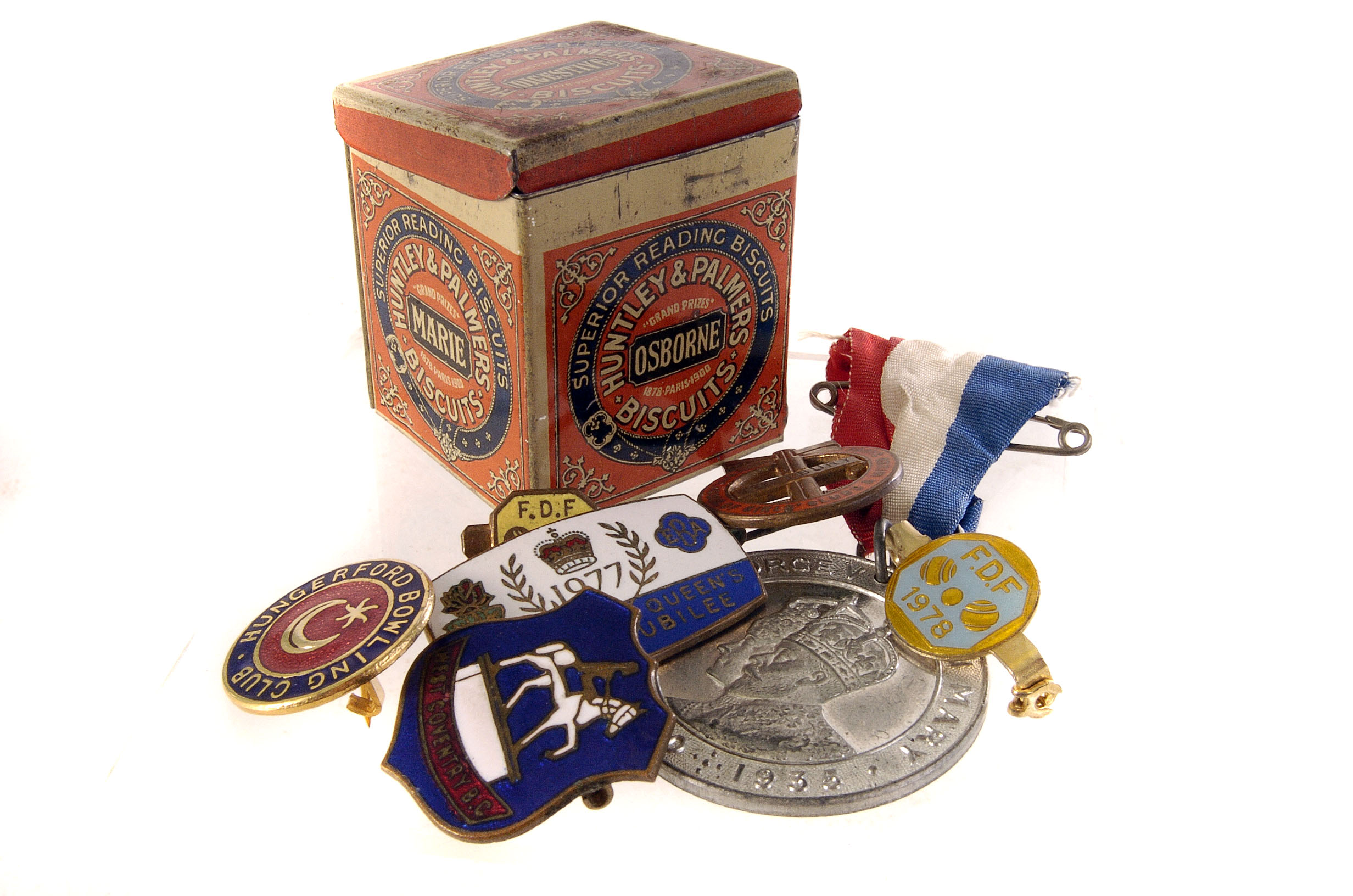 A small Huntley and Palmers biscuit tin, together with a small selection of badges and a medal,
