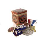 A small Huntley and Palmers biscuit tin, together with a small selection of badges and a medal,