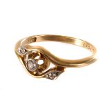 An 18ct gold three stone diamond ring, the central brilliant cut stone, flanked by dual crossover