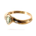 A 9ct gold diopsite and diamond ring, the pear cut green stone mounted in 9ct gold, flanked by