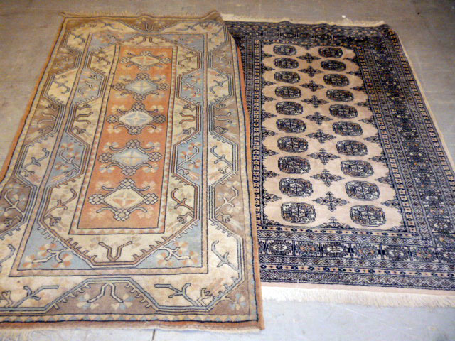 Two machine made carpets, both of beige ground, approx. 202cm by 114cm and smaller