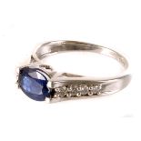 A 9ct white gold, sapphire and diamond ring, the oval cut stone mounted in claw setting with pierced