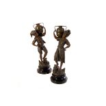 A pair of spelter figures of a boy and girl carrying an urn, having H.Tremo impressed to base,
