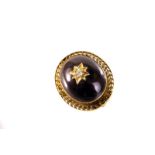 A Victorian garnet and diamond mourning brooch, the cabochon red foil backed stone centred with an