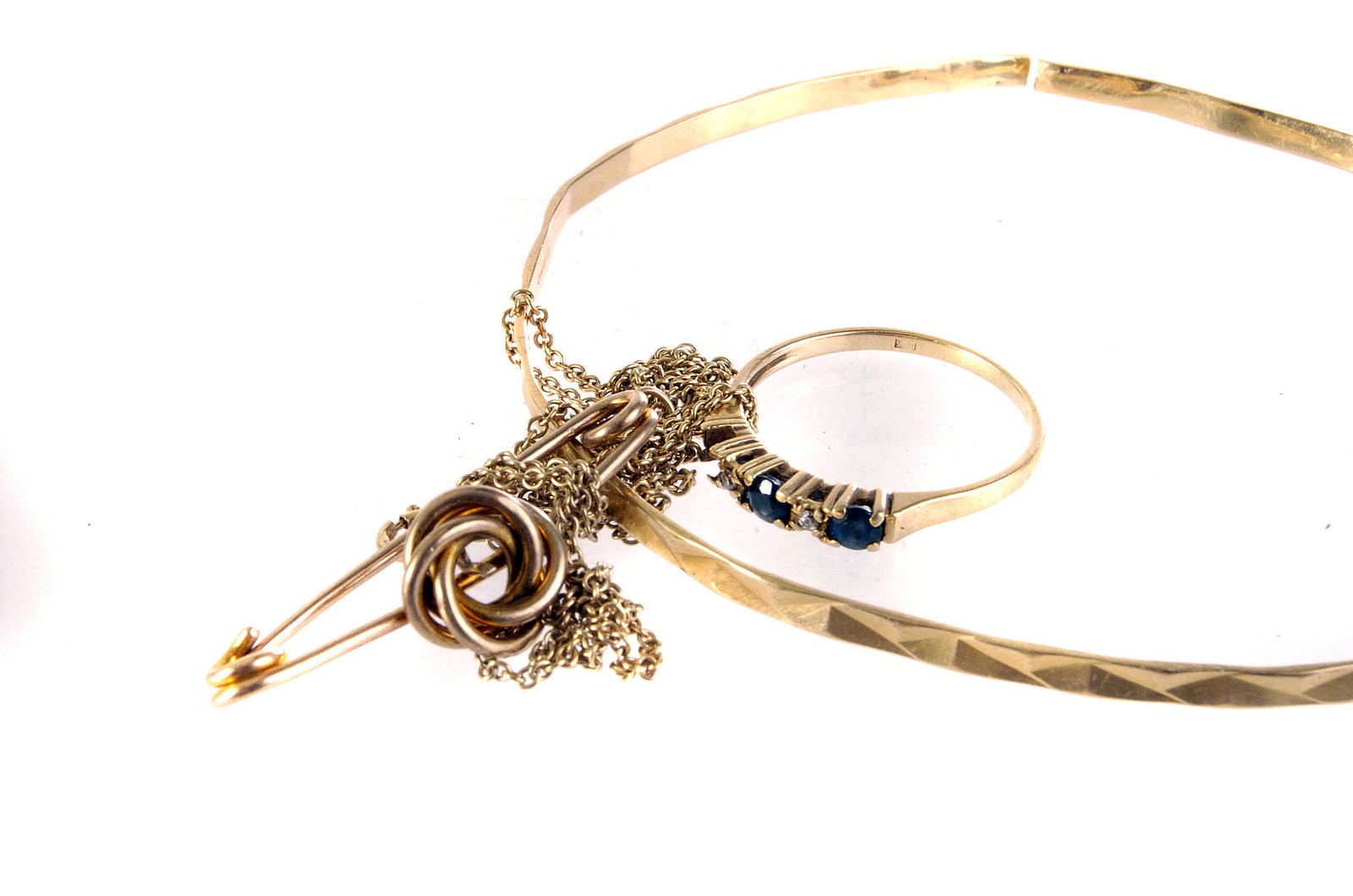 An 18ct gold broken bangle, together with three yellow metal items, including a gem set ring, a knot