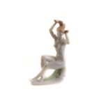 A continental Quincum porcelain figure of a seated female nude, the seated nude doing her hair,