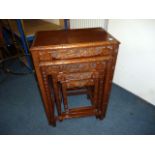 A nest of four Chinese hardwood tables, having carved oriental scenes to side, with lower stretcher