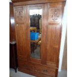 A modern walnut single door wardrobe, having central mirrored door, flanked by two florally carved