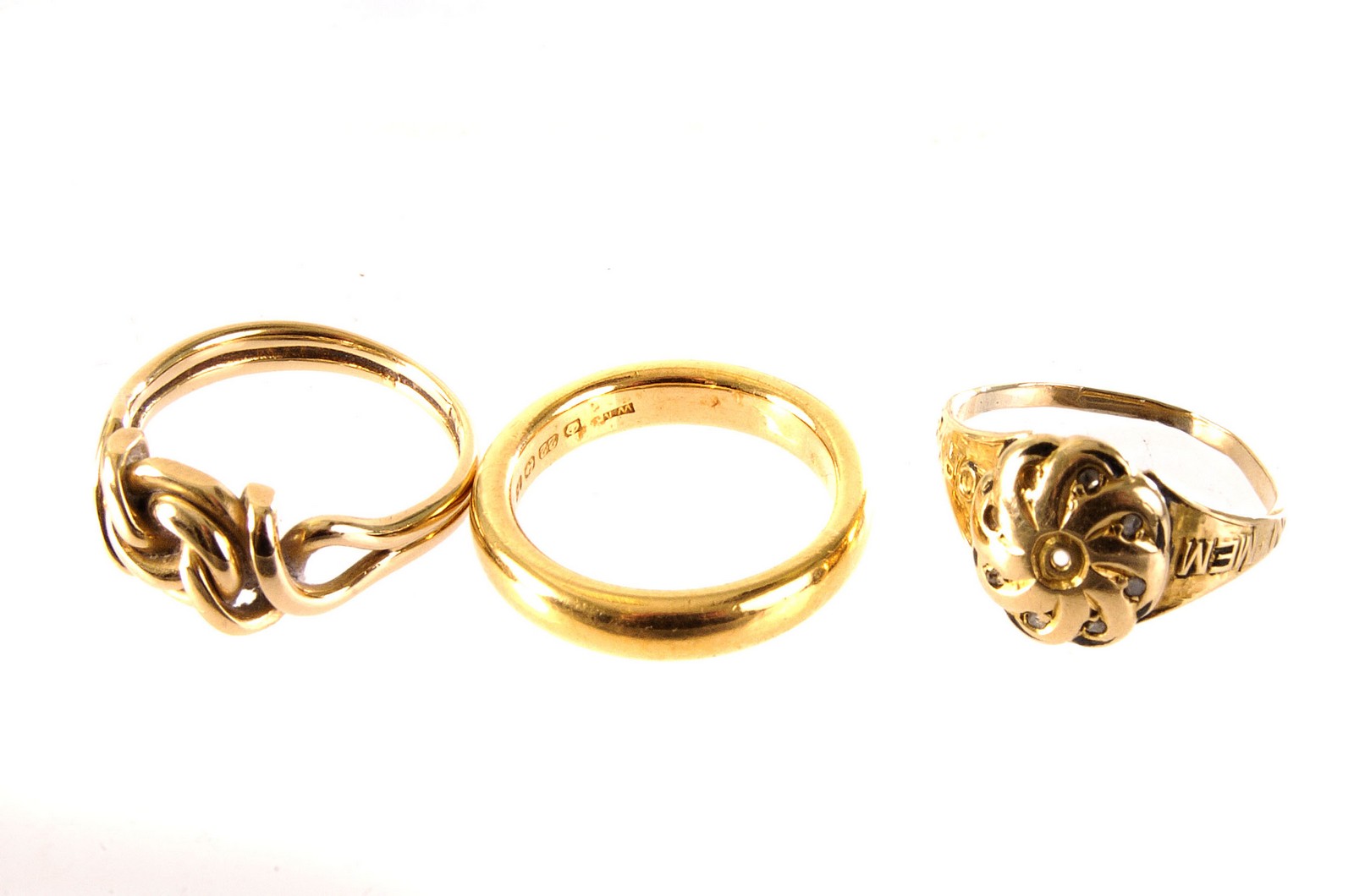 Three gold rings, including a 22ct gold wedding band, an 18ct gold knot ring marked Chester, and