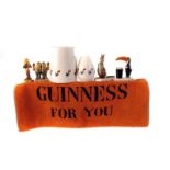 A large collection of Guinness related items, including Wade figures, ashtrays, a bar towel, salt