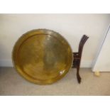 A Middle Eastern brass tray top table, having animal amongst foliate engraved decoration, on