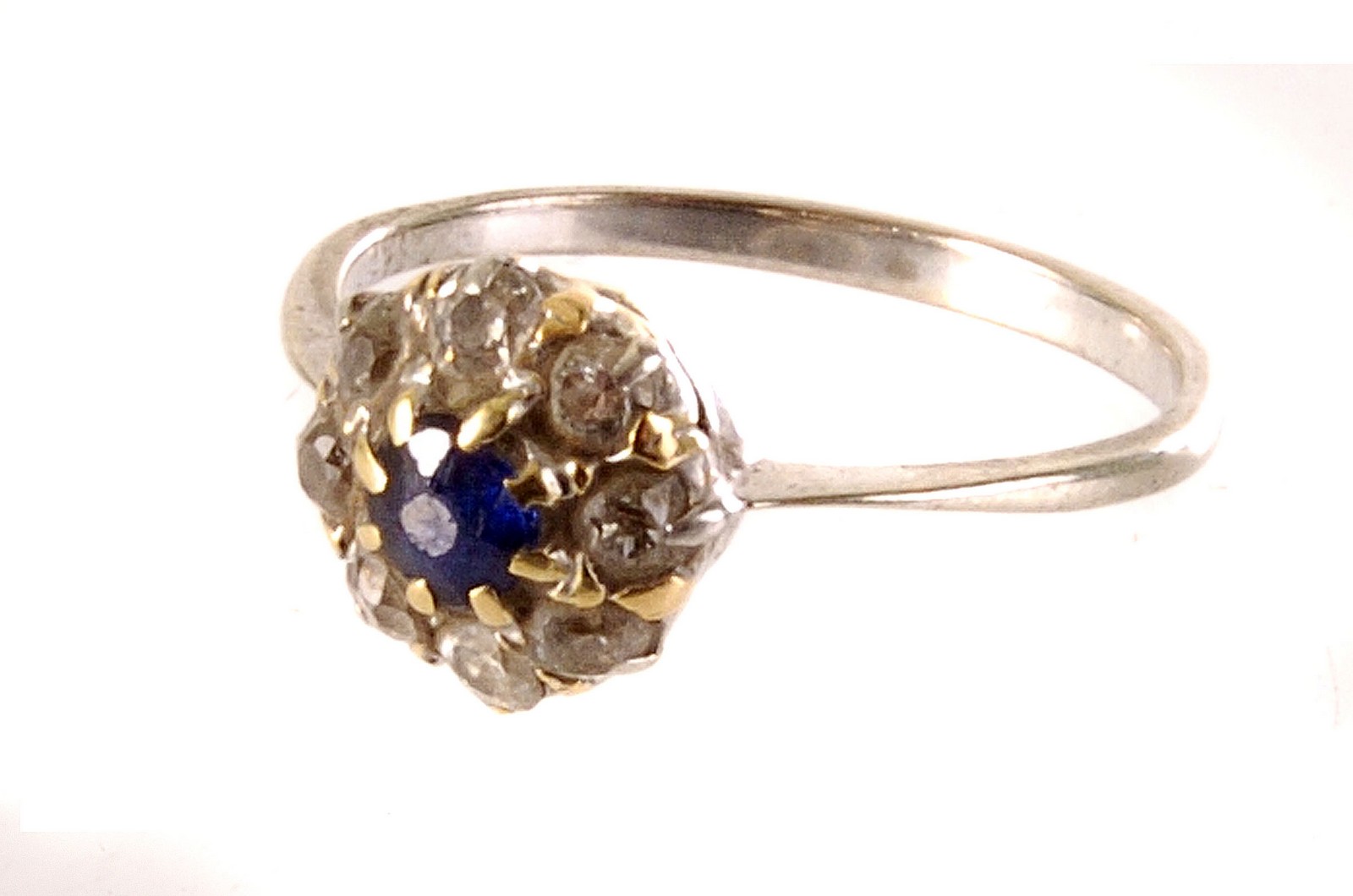 A sapphire and diamond cluster ring, the central round cut sapphire surrounded by brilliant cut