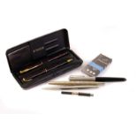 A collection of pens, including a Parker tortoiseshell fountain pen and pencil set, a Parker 51, a