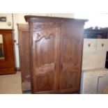 A French walnut armoire, having decorative carved foliate design to doors and top, approx 228cm H