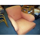 A red upholstered Howard style chair, on turned legs, on casters