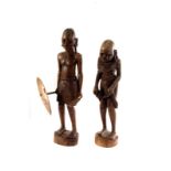 A pair of African carved wooden figure, one of a warrior with spear and shield, the other of a