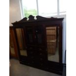 A large late Victorian compactum wardrobe, the vase and swag carved panel cupboard over chest of