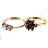 An 18ct gold three stone diamond ring, the three brilliant cut stones set in white metal on 18ct
