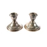 A pair of silver dwarf candlesticks, marked Wallace Sterling 4488 to base, with weighted base