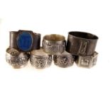 A selection of white metal and Indian silver napkin rings, all with various designs, together with a