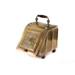 A vintage brass coal scuttle, having lion mask design to front, on four short legs