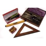 A selection of geometry and calligraphy equipment, including pen nibs, a pencil sharpener, rulers,