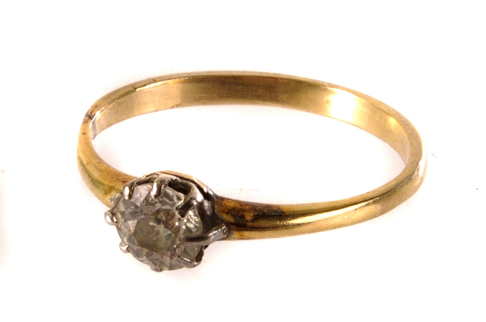 A diamond solitaire, the brilliant cut diamond mounted on a yellow metal band