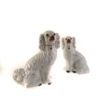 Two pairs of Staffordshire pottery dogs, both of similar design, the white glaze ground with gilt