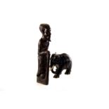 An African carved figure of an elderly gentleman, together with a selection of ebony elephant