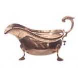 A good quality George V silver sauce boat, having gadrooned rim, C scroll handle, on three shell