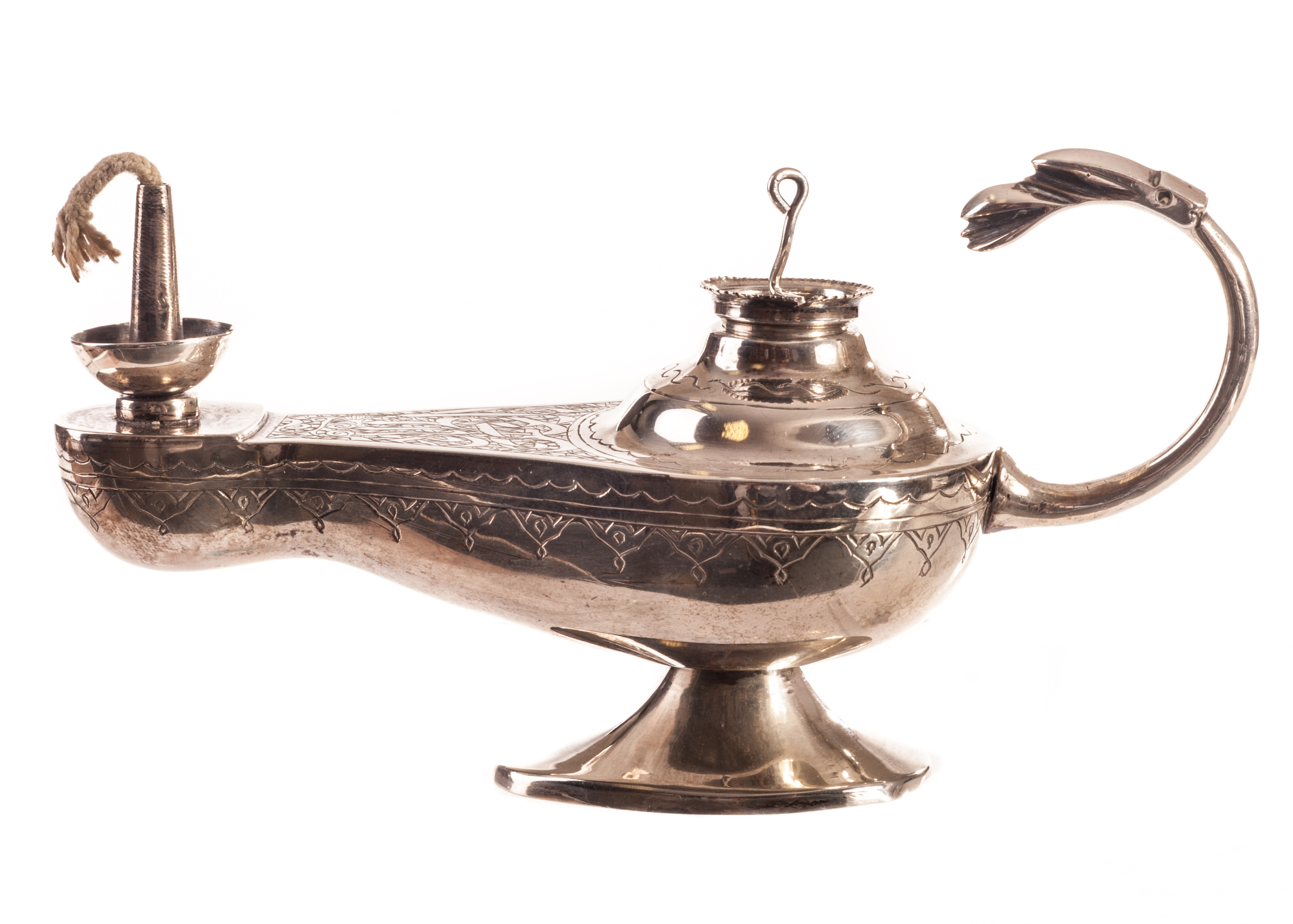 A Middle Eastern white metal oil lamp table lighter, having engraved script to upper with a stylised