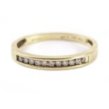 An 18ct gold and diamond half hoop eternity ring, having a row of small brilliant cuts, marked to